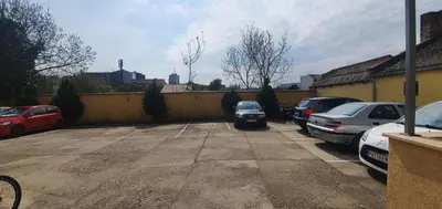a parking lot with cars parked next to a wall at Julija 2 in Pančevo