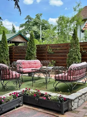 a garden with two chairs and a table and flowers at Vila Aleksić in Smederevo
