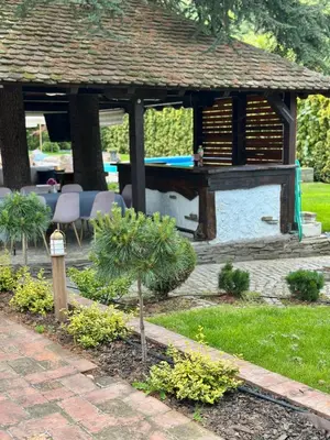 a garden with a gazebo with a table and chairs at Vila Aleksić in Smederevo