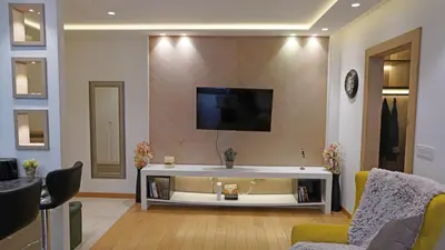 a living room with a tv on a wall at Captain's Apartment in Karaburma