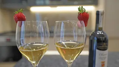 two glasses of white wine with strawberries on them at Captain's Apartment in Karaburma