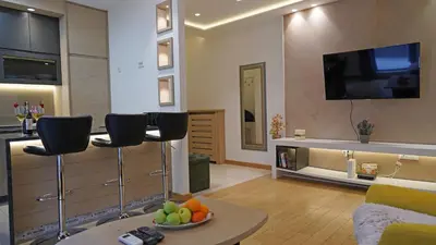 a living room with a couch and a tv on a wall at Captain's Apartment in Karaburma