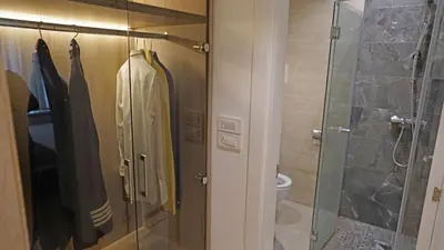 a bathroom with a shower stall and a robe at Captain's Apartment in Karaburma