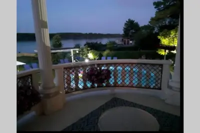 a balcony with a railing with a view of the water at Villa Danube , 25 min from Belgrade, 20 min Airport, Private Pool & Sauna in Novi Banovci