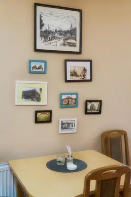 a dining room table with pictures on the wall at Vila Chess in Belgrade