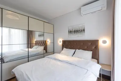 a bedroom with a large white bed and a mirror at Belgrade Center Apartment Lux in Belgrade