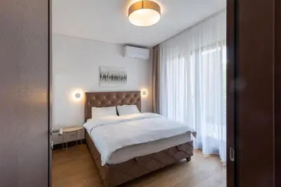 a bedroom with a bed and a large window at Belgrade Center Apartment Lux in Belgrade
