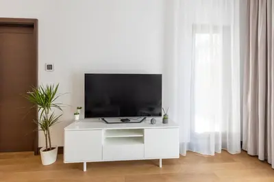 a living room with a white cabinet with a television on it at Belgrade Center Apartment Lux in Belgrade