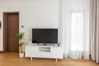 a white cabinet with a tv on it in a living room at Belgrade Center Apartment Lux in Belgrade