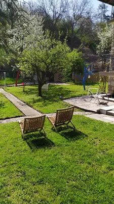 two benches sitting in the grass in a park at Šumski Raj- Forest Paradise in Velika Remeta