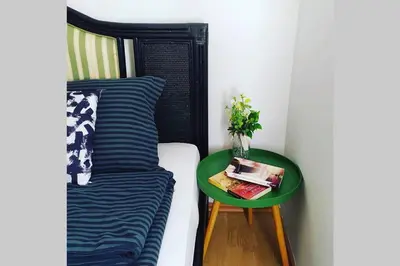 a green table next to a bed and a table with a pillow at Šumski Raj- Forest Paradise in Velika Remeta