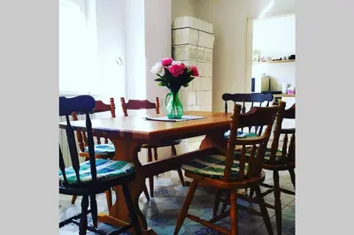 a dining room table with a vase of flowers on it at Šumski Raj- Forest Paradise in Velika Remeta