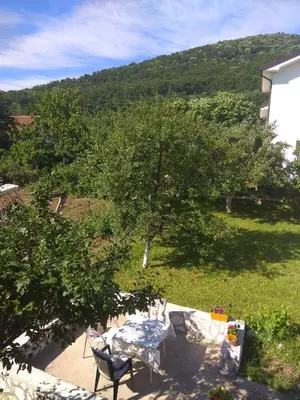 a table and chairs on a patio with a tree at APARTMAN U BUKOVICKOJ BANJI ARANDJELOVAC in Arandjelovac