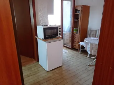a kitchen with a microwave on top of a refrigerator at APARTMAN U BUKOVICKOJ BANJI ARANDJELOVAC in Arandjelovac