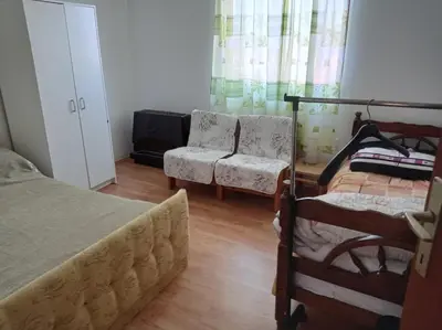 a bedroom with a bed and a couch and a chair at APARTMAN U BUKOVICKOJ BANJI ARANDJELOVAC in Arandjelovac