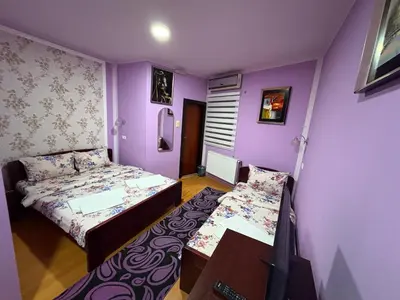 two beds in a room with purple walls at Villa Atina in Stara Pazova