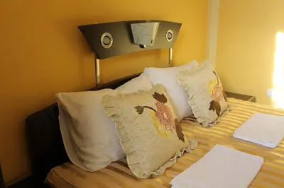 a bedroom with a bed with pillows on it at Villa Atina in Stara Pazova