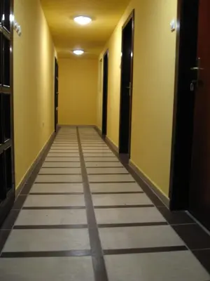 an empty hallway with yellow walls and a long corridor at Villa Atina in Stara Pazova