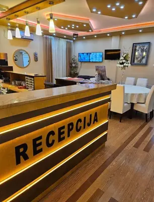 a hotel lobby with a reception counter and a restaurant at Villa Atina in Stara Pazova