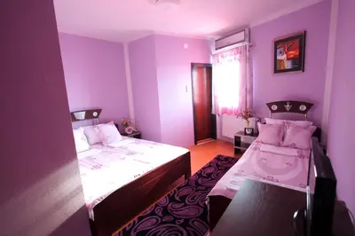 a purple room with two beds and a window at Villa Atina in Stara Pazova
