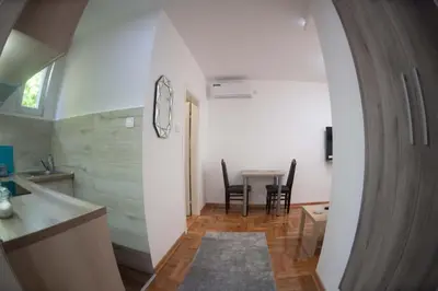a kitchen and living room with a table and chairs at APARTMAN TEA 2 in Belgrade