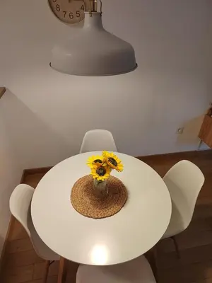 a white table with a vase with flowers on it at Yellow Gate in Novi Grad