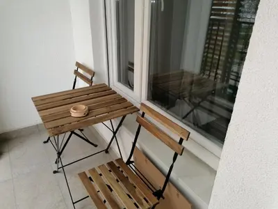 a wooden table and a chair in front of a window at Yellow Gate in Novi Grad