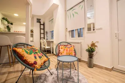 a living room with two chairs and a table at KARIOKA apartman in Belgrade
