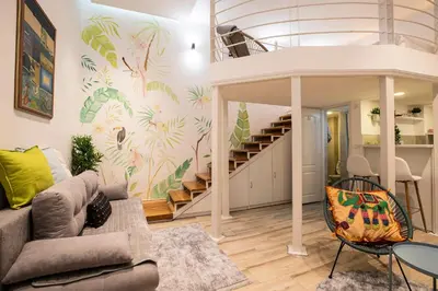a living room with a couch and a staircase at KARIOKA apartman in Belgrade