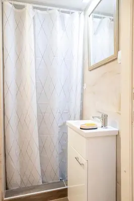 a bathroom with a shower curtain and a sink at KARIOKA apartman in Belgrade