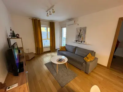 a living room with a couch and a tv at Zemunske Kapije Yellow Gate in Novi Grad
