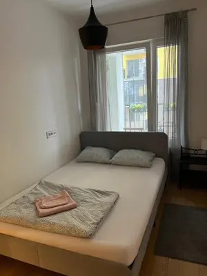 a bed in a room with a large window at Zemunske Kapije Yellow Gate in Novi Grad