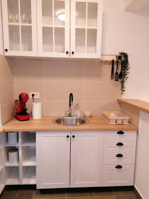 a kitchen with white cabinets and a sink at Zemunske Kapije Yellow Gate in Novi Grad