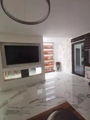 a living room with a television and a marble floor at Excellent Time in Belgrade