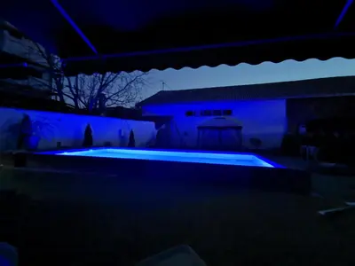 a swimming pool in the dark with blue lights at Excellent Time in Belgrade