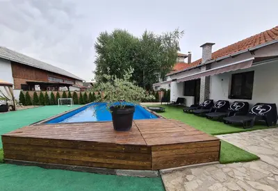 a swimming pool with a wooden deck in a backyard at Excellent Time in Belgrade