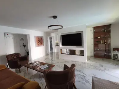 a living room with a couch and a tv on a wall at Excellent Time in Belgrade