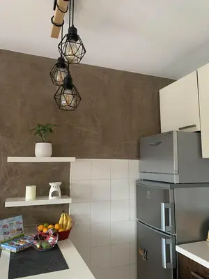 a kitchen with a bowl of fruit and a refrigerator at Apartman ANN in Pančevo
