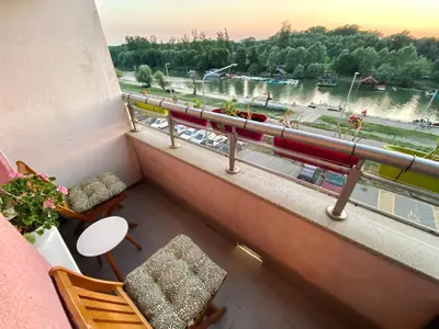 a balcony with chairs and a view of a river at Apartman ANN in Pančevo