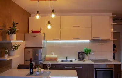 a kitchen with white cabinets and a sink at Apartman ANN in Pančevo