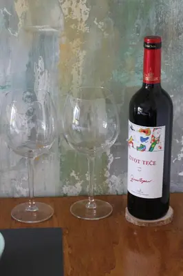 a bottle of wine and two wine glasses on a table at Wellport30 in Belgrade