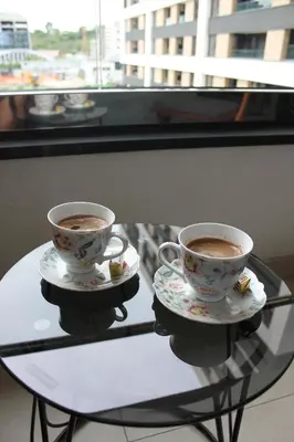 two cups of coffee sitting on a glass table at Wellport30 in Belgrade