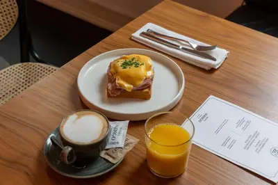 a table with a plate of doughnut and a glass of orange juice at Hotel Indigo Belgrade by IHG in Belgrade