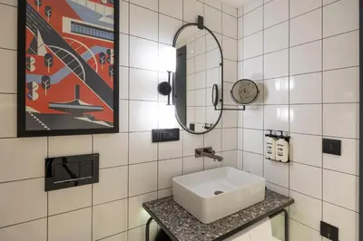 a white bathroom with a sink and a mirror at Hotel Indigo Belgrade by IHG in Belgrade