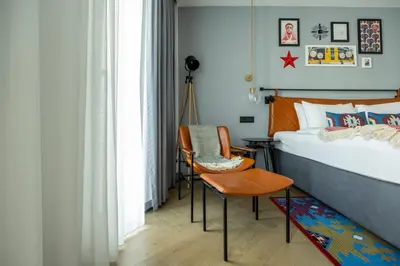 a bedroom with a bed and a chair and a table at Hotel Indigo Belgrade by IHG in Belgrade