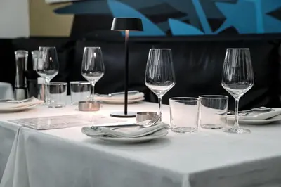 a table with wine glasses and plates on it at Hotel Indigo Belgrade by IHG in Belgrade