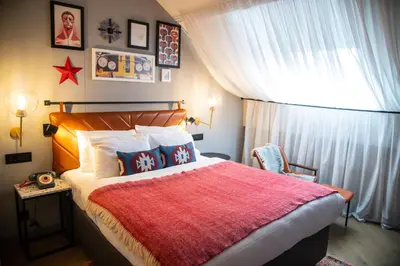 a bedroom with a large bed with a red blanket at Hotel Indigo Belgrade by IHG in Belgrade