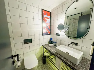 a bathroom with a sink and a toilet and a mirror at Hotel Indigo Belgrade by IHG in Belgrade