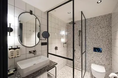 a bathroom with a sink and a toilet and a mirror at Hotel Indigo Belgrade by IHG in Belgrade