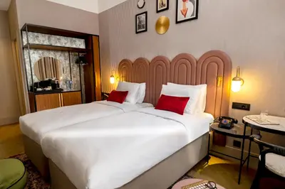a bedroom with two large white beds with red pillows at Hotel Indigo Belgrade by IHG in Belgrade